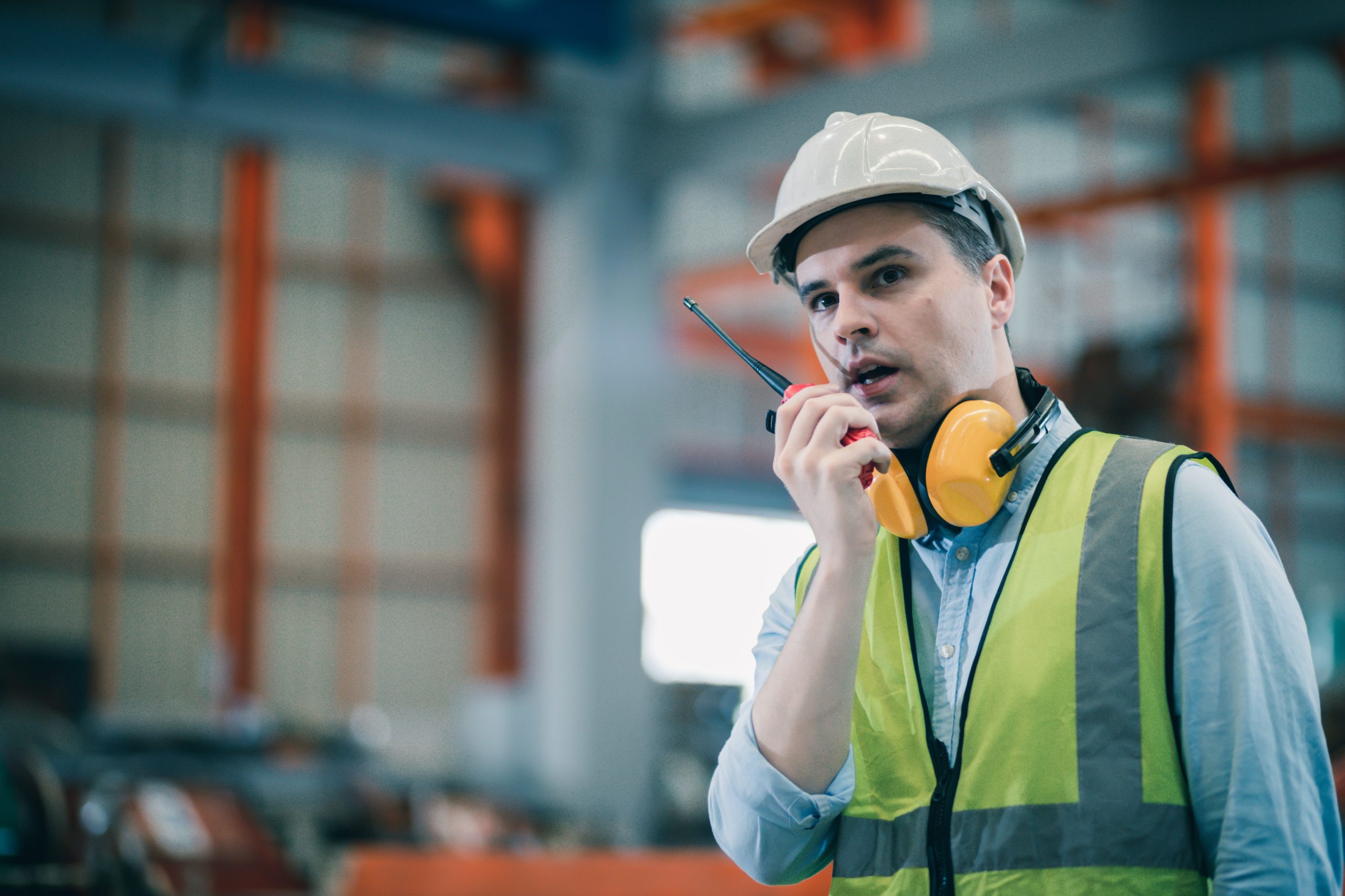 Industrial worker in factory site he communicating with a walkie talkie call working professional.